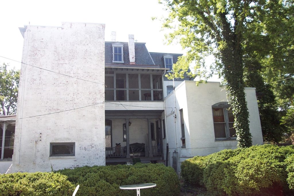 The monolithic massing of the East (kitchen--on left) and West (Doctor's office--on right) Wings on the rear of the house