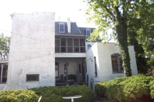 The monolithic massing of the East (kitchen--on left) and West (Doctor's office--on right) Wings on the rear of the house